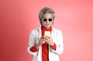 Pembe arka planda duran Asyalı adam..