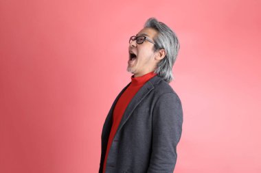 Pembe arka planda duran Asyalı adam..