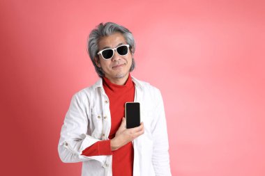 Pembe arka planda duran Asyalı adam..