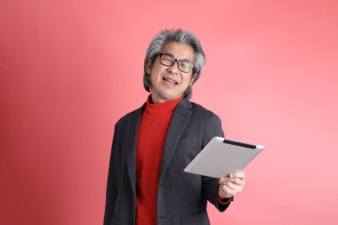 Pembe arka planda duran Asyalı adam..