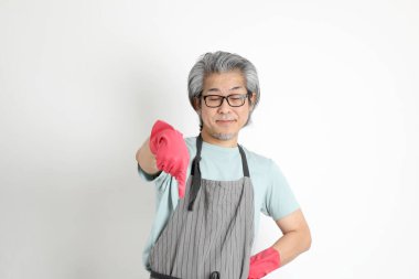 Beyaz arka planda duran kıdemli Asyalı hizmetçi..