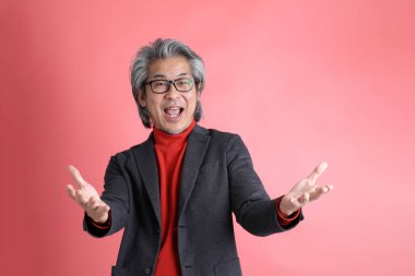 Pembe arka planda duran Asyalı adam..