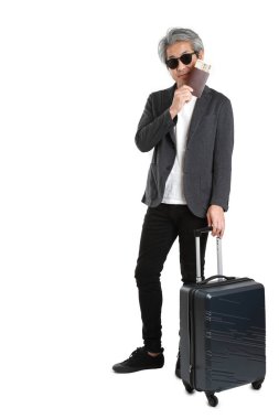 Beyaz arka planda bagajı olan kıdemli Asyalı işadamı..