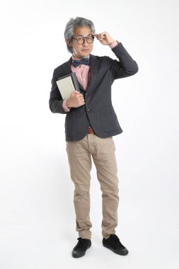 Beyaz arka planda duran kıdemli Asyalı öğretmen..