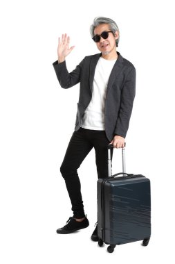 Beyaz arka planda bagajı olan kıdemli Asyalı işadamı..