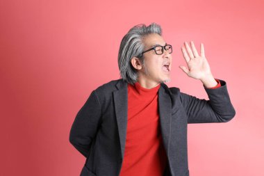 Pembe arka planda duran Asyalı adam..