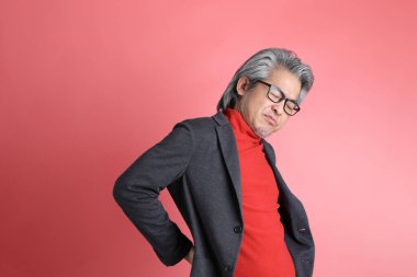 Pembe arka planda duran Asyalı adam..