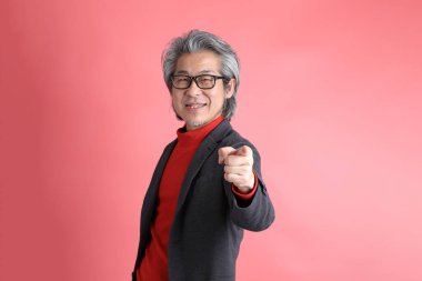 Pembe arka planda duran Asyalı adam..