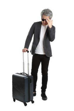 Beyaz arka planda bagajı olan kıdemli Asyalı işadamı..