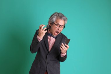 Yeşil arka planda duran kıdemli Asyalı öğretmen..