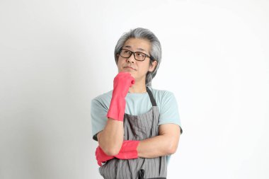 Beyaz arka planda duran kıdemli Asyalı hizmetçi..