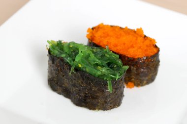 Beyaz arka planda suşi adı verilen Japon yemeği..