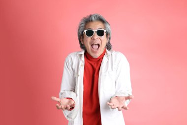 Pembe arka planda duran Asyalı adam..