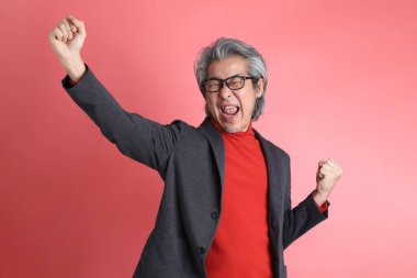 Pembe arka planda duran Asyalı adam..