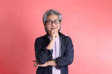 Pembe arka planda duran Asyalı adam..