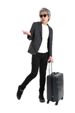 Beyaz arka planda bagajı olan kıdemli Asyalı işadamı..