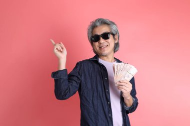 Pembe arka planda duran Asyalı adam..