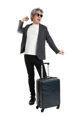 Beyaz arka planda bagajı olan kıdemli Asyalı işadamı..