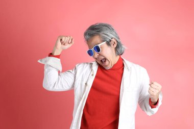 Pembe arka planda duran Asyalı adam..