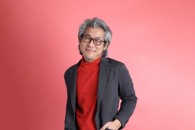 Pembe arka planda duran Asyalı adam..