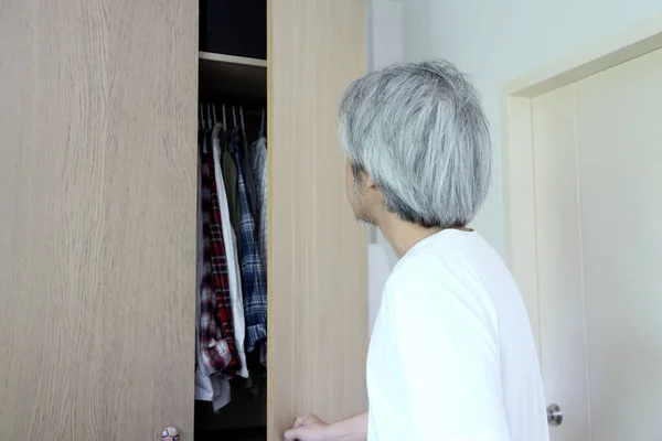 那个在卧室里挑选衣服的亚裔老人 — 图库照片