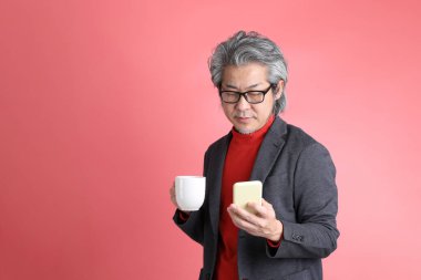 Pembe arka planda duran Asyalı adam..