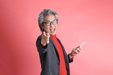 Pembe arka planda duran Asyalı adam..