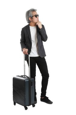 Beyaz arka planda bagajı olan kıdemli Asyalı işadamı..