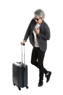 Beyaz arka planda bagajı olan kıdemli Asyalı işadamı..