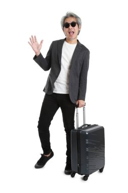 Beyaz arka planda bagajı olan kıdemli Asyalı işadamı..