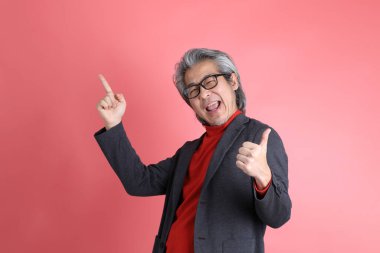 Pembe arka planda duran Asyalı adam..