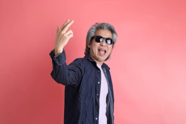 Pembe arka planda duran Asyalı adam..