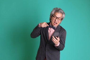 Yeşil arka planda duran kıdemli Asyalı öğretmen..