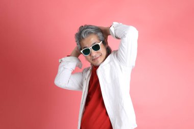 Pembe arka planda duran Asyalı adam..