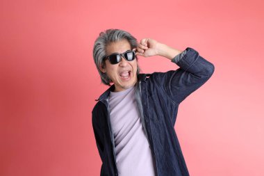 Pembe arka planda duran Asyalı adam..