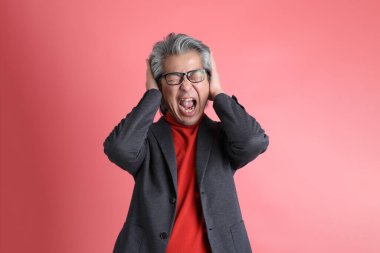 Pembe arka planda duran Asyalı adam..