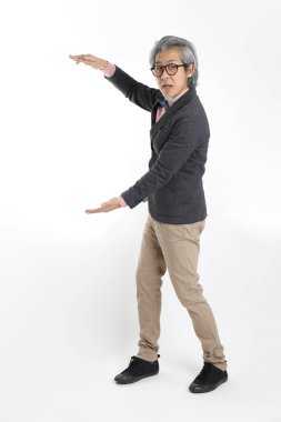 Beyaz arka planda duran kıdemli Asyalı öğretmen..