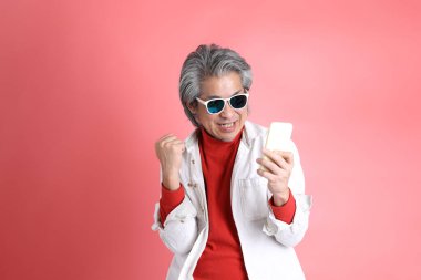 Pembe arka planda duran Asyalı adam..