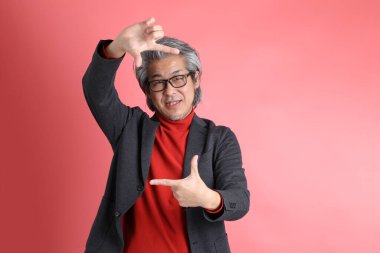 Pembe arka planda duran Asyalı adam..