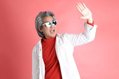 Pembe arka planda duran Asyalı adam..