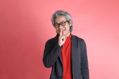 Pembe arka planda duran Asyalı adam..