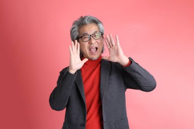 Pembe arka planda duran Asyalı adam..