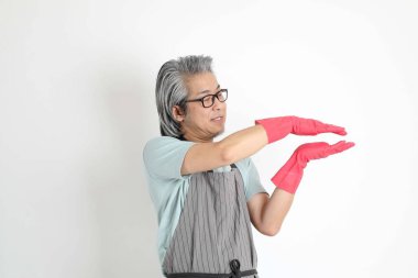 Beyaz arka planda duran kıdemli Asyalı hizmetçi..