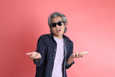 Pembe arka planda duran Asyalı adam..