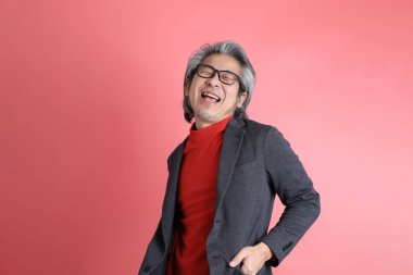 Pembe arka planda duran Asyalı adam..