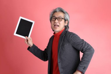 Pembe arka planda duran Asyalı adam..