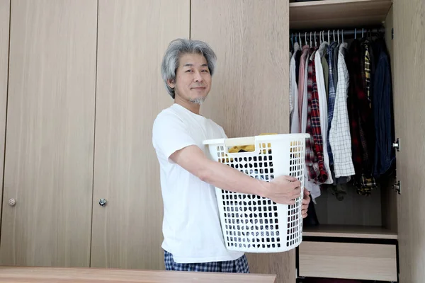 洗濯をするために服のバスケットを持っているアジアの男 — ストック写真