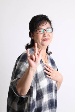 Beyaz arka planda duran yaşlı Asyalı kadın..