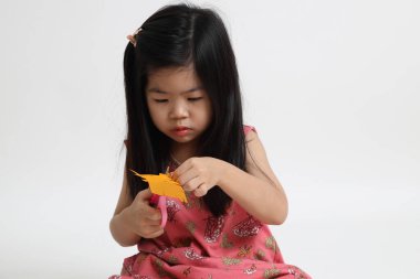 Kağıdı kesmek için makas kullanan Asyalı kız..