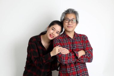 Farklı yaşlarda beyaz arka planda duran Asyalı çift..